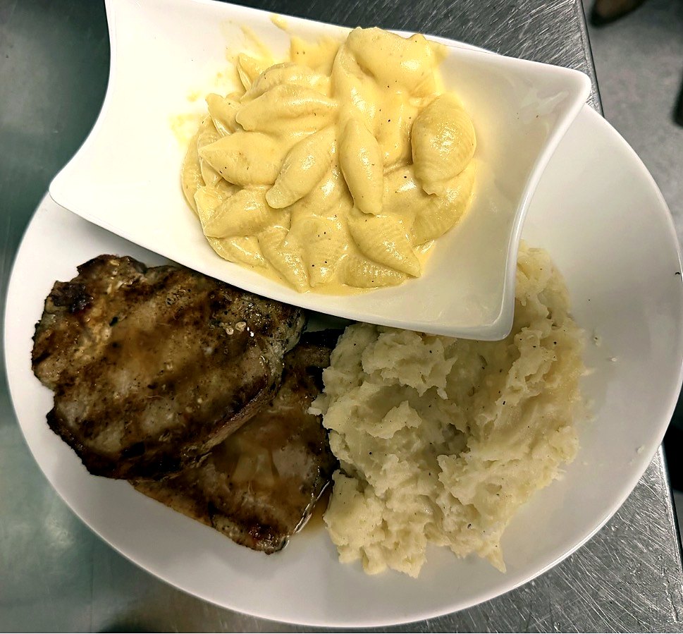 Grilled chop with mac and cheese and mashed potatoes