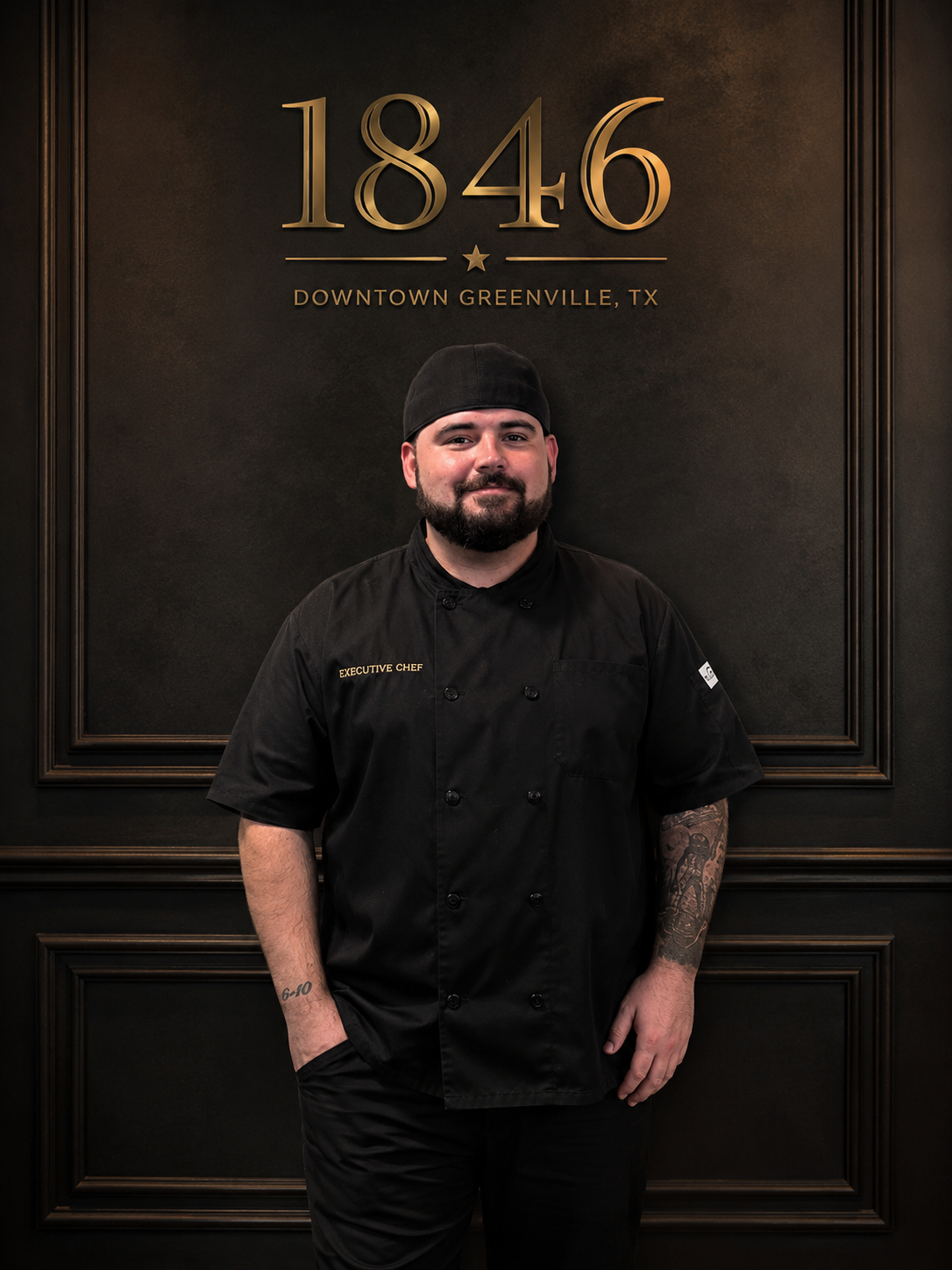 Head Chef Matthew Rogers photographed beneath the 1846 crest in downtown Greenville, Texas